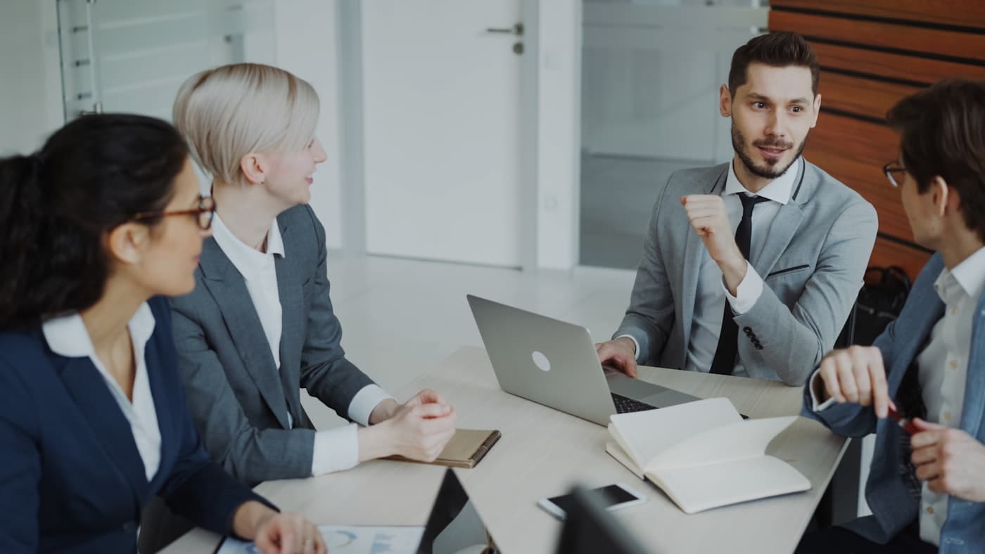Une équipe en discussion autour d'une table dans un bureau lumineux