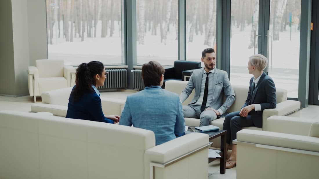 Un petit groupe en discussion dans un salon de réunion lumineux