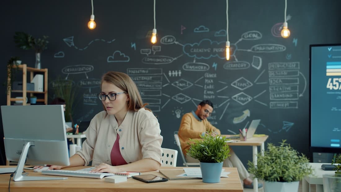 Una team lead controlla i progressi degli studenti alla scrivania