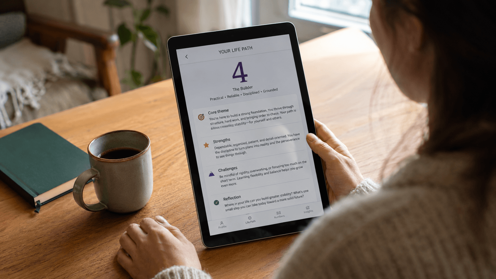 Pessoa explorando um perfil personalizado do caminho de vida 4 em um aplicativo de numerologia no tablet