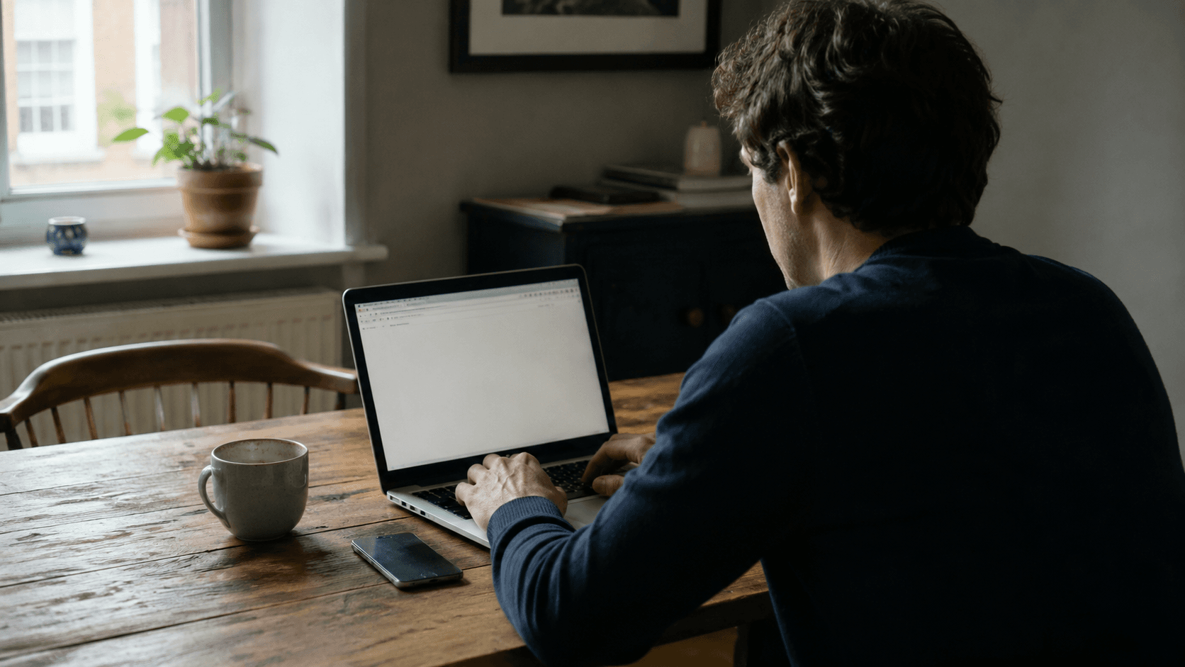 A person's hand hovering over a keyboard, poised to type, focused stillness before starting