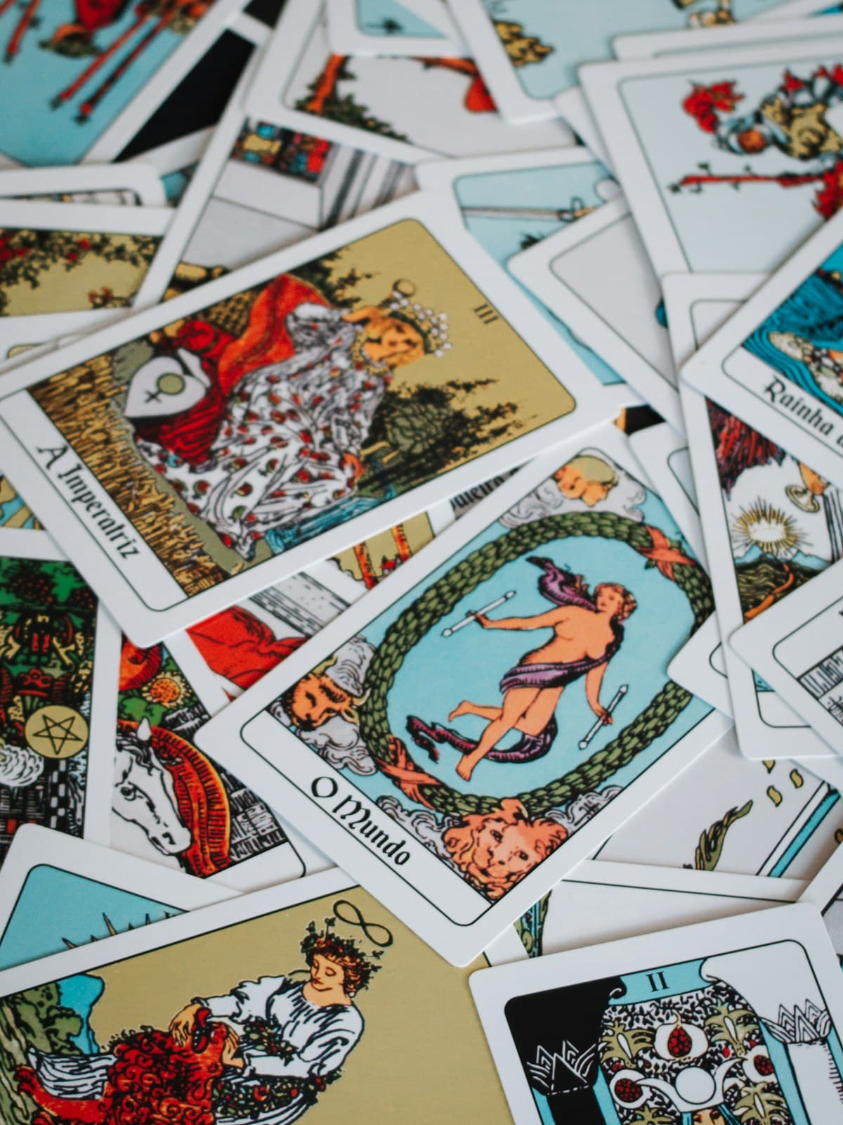 Dozens of illustrated tarot cards scattered across a table
