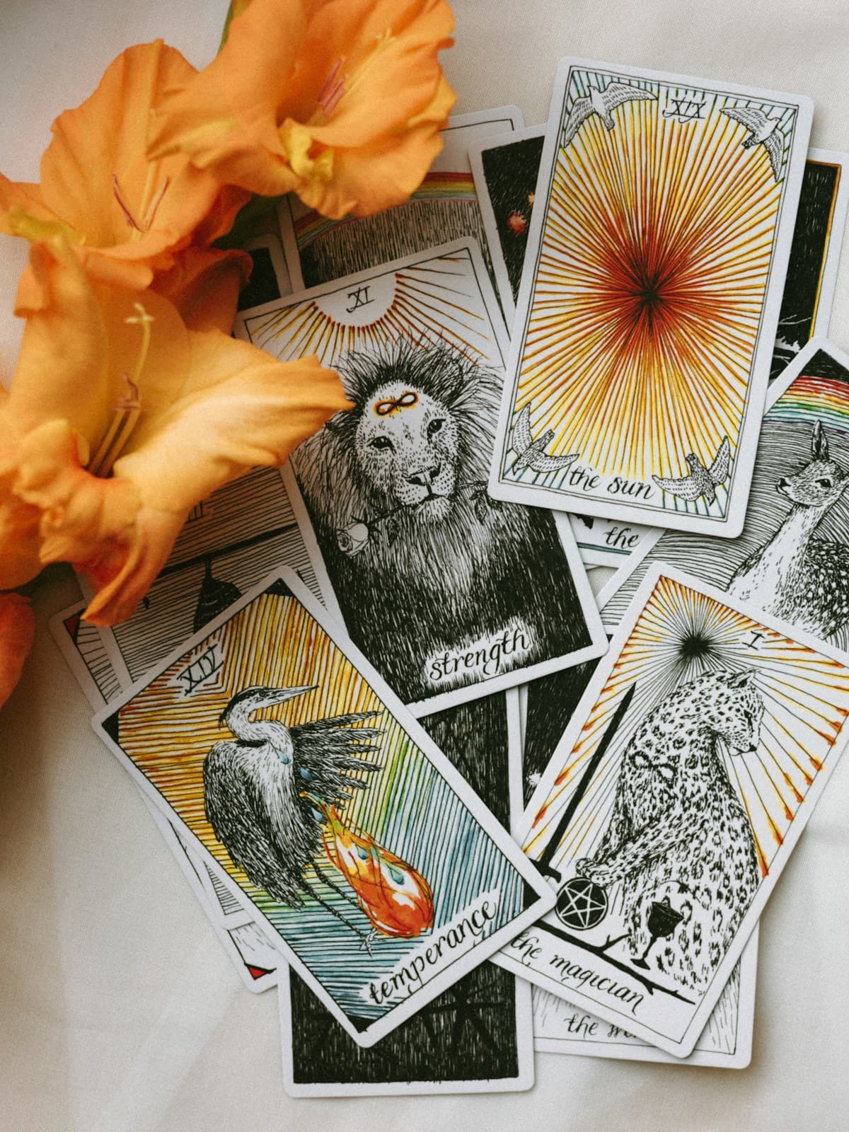 Cartas de tarô espalhadas em uma mesa com flores laranjas